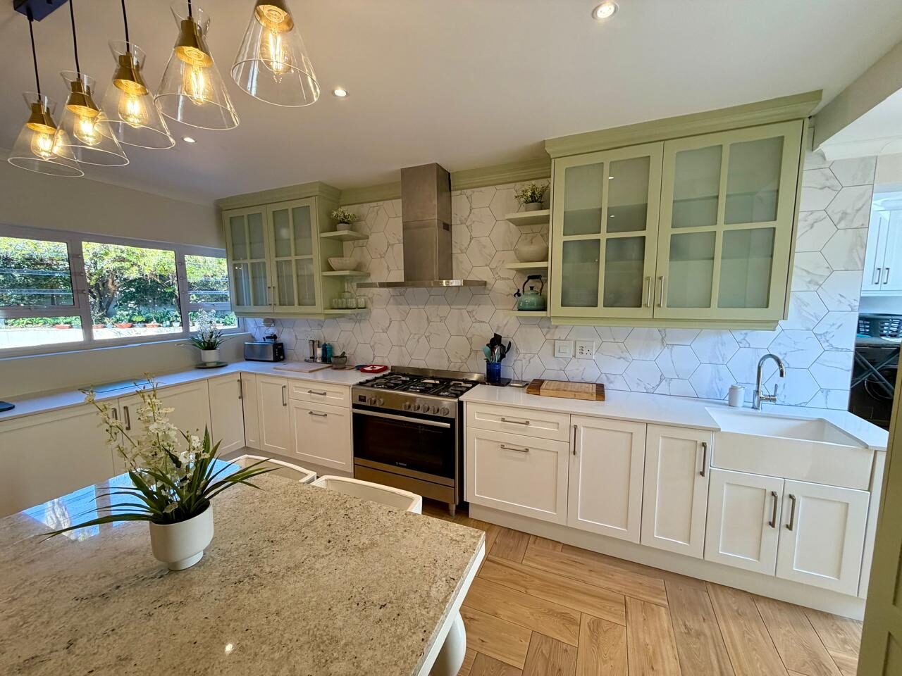 Sage green shaker kitchen with hexagon marble splashback